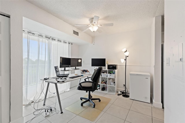 tiled office space with a textured ceiling and ceiling fan