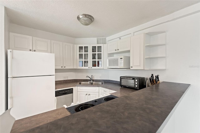 kitchen featuring white appliances, white cabinets, sink, a textured ceiling, and kitchen peninsula