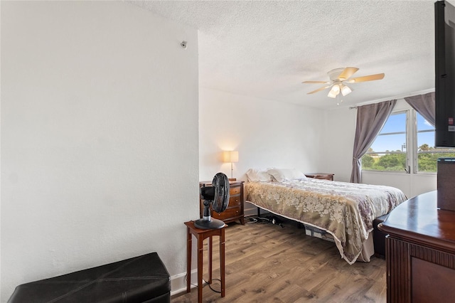 bedroom with hardwood / wood-style floors, a textured ceiling, and ceiling fan