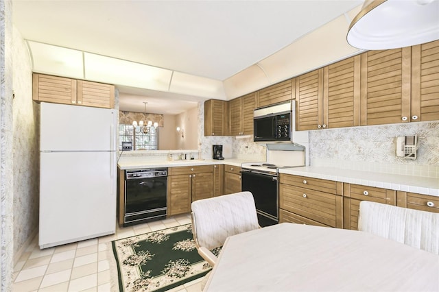 kitchen featuring dishwasher, hanging light fixtures, electric range oven, white fridge, and a chandelier