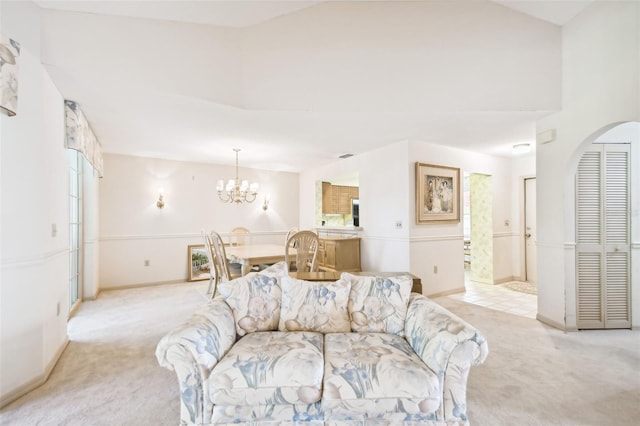 living room with a notable chandelier and light colored carpet