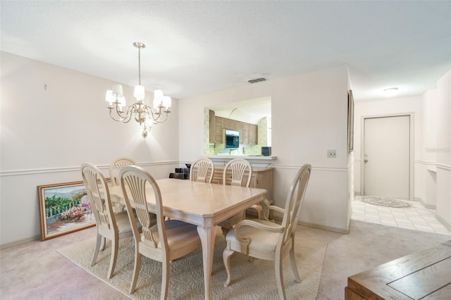 carpeted dining space with a chandelier