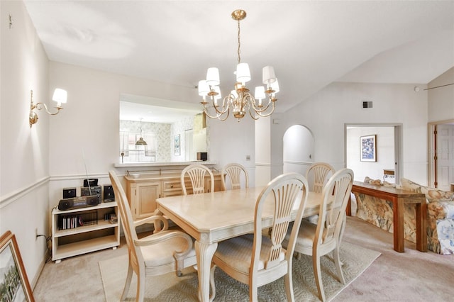 dining space featuring a chandelier, light colored carpet, and vaulted ceiling