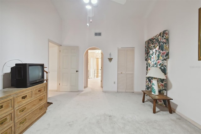 interior space featuring light carpet, a closet, and a high ceiling