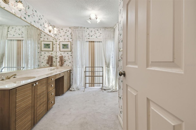 bathroom with plenty of natural light, a textured ceiling, and vanity