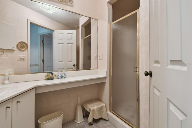 bathroom with a textured ceiling, vanity, and an enclosed shower