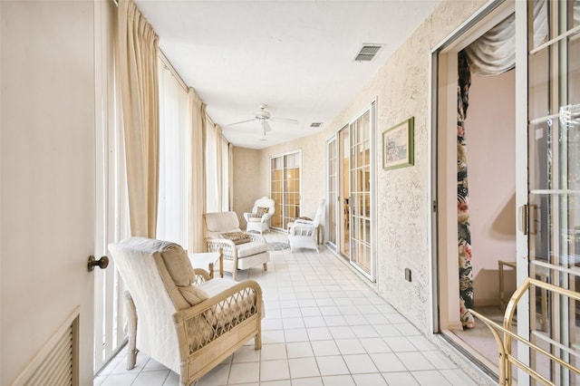 sunroom / solarium featuring ceiling fan and french doors