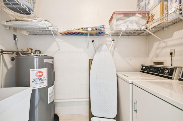 clothes washing area featuring sink, washing machine and dryer, and water heater