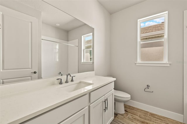 bathroom featuring hardwood / wood-style flooring, plenty of natural light, toilet, and a shower