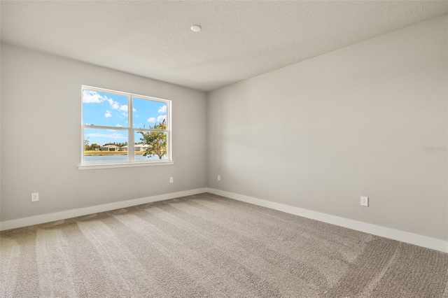 empty room with a textured ceiling and carpet flooring