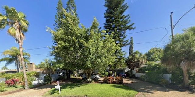 505 80th Ave, St Pete Beach, FL 33706 - view of front facade with driveway and a front yard