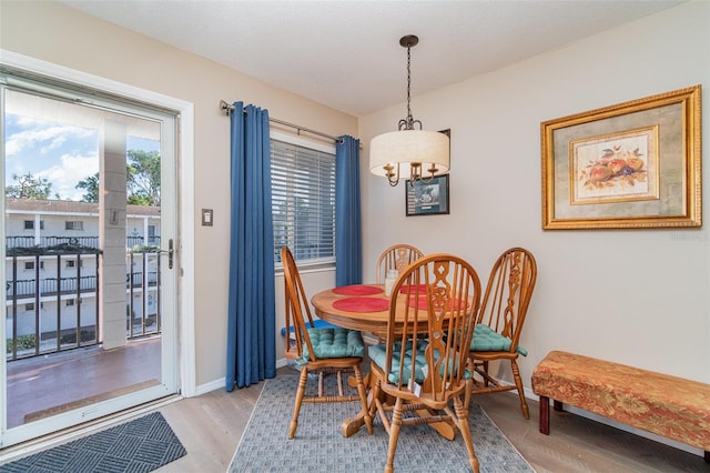 dining area with light hardwood / wood-style flooring and an inviting chandelier