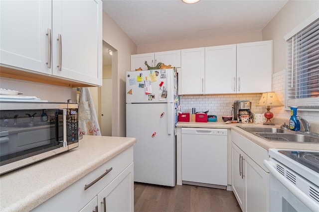 kitchen featuring sink, dark wood-type flooring, white appliances, decorative backsplash, and white cabinets