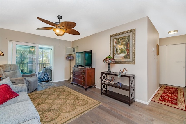 living room with a wall mounted AC, ceiling fan, and hardwood / wood-style flooring