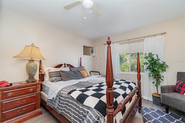 bedroom featuring ceiling fan, light wood-type flooring, a textured ceiling, and a wall unit AC