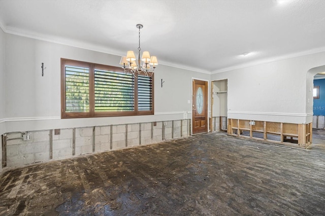 spare room featuring crown molding and a chandelier