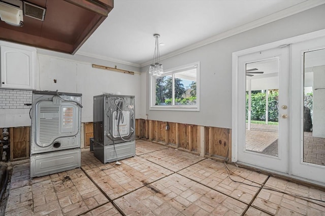 kitchen featuring decorative backsplash, wooden walls, crown molding, white cabinetry, and hanging light fixtures