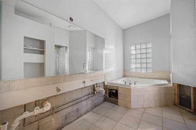 bathroom with tile patterned flooring and tiled bath