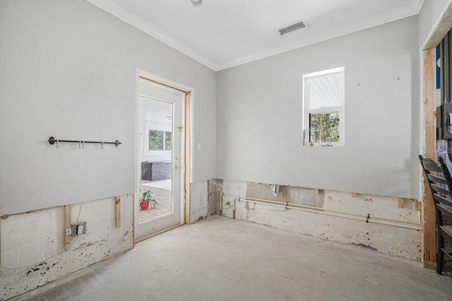 spare room featuring crown molding, plenty of natural light, and concrete floors