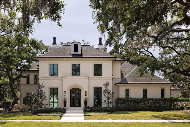 french country inspired facade with a front lawn and french doors