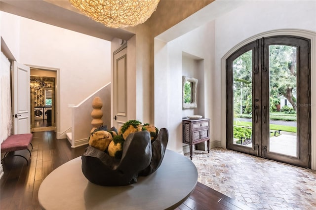 foyer entrance featuring a towering ceiling, dark wood-type flooring, and french doors