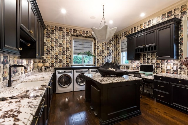 kitchen with ornamental molding, sink, decorative light fixtures, separate washer and dryer, and dark hardwood / wood-style floors