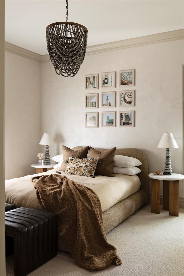 carpeted bedroom with ornamental molding and a chandelier