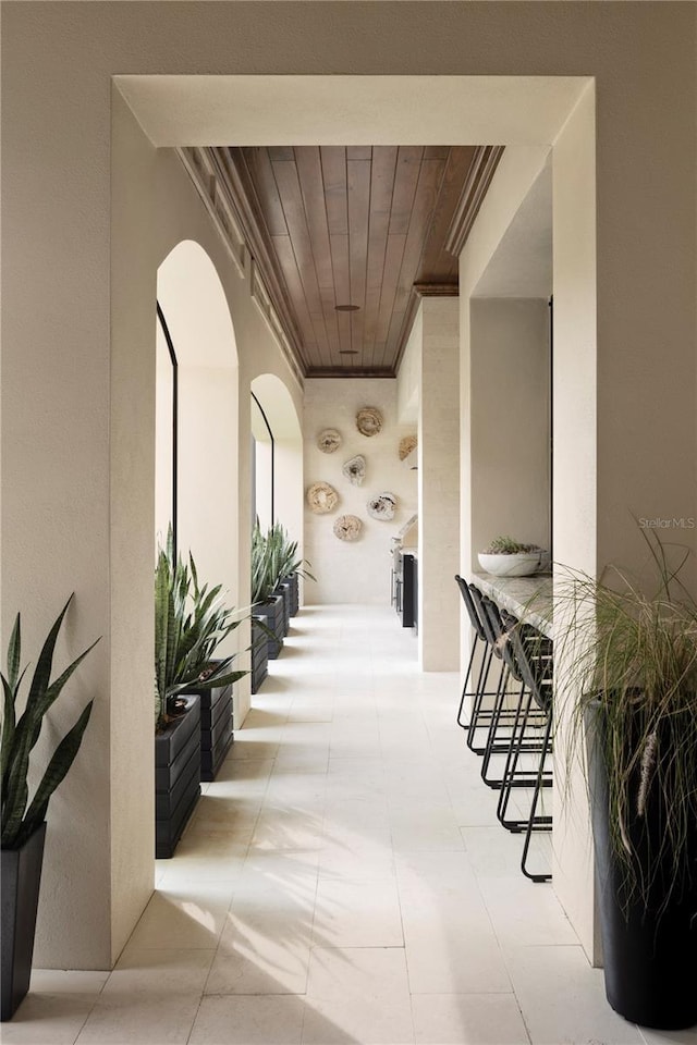 hallway featuring wooden ceiling and ornamental molding