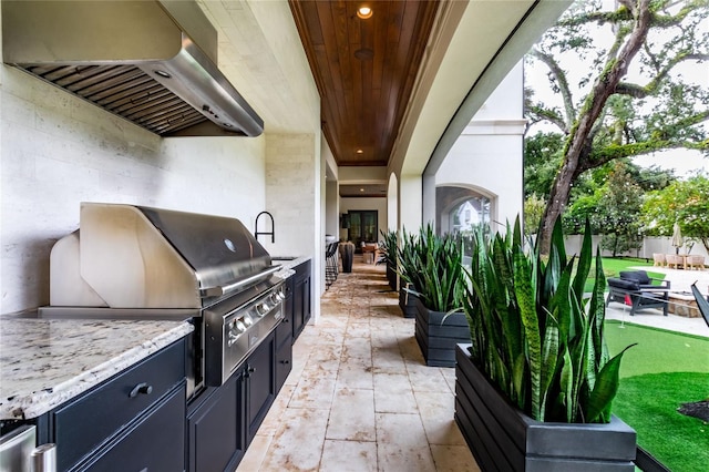 view of patio with area for grilling, sink, and exterior kitchen