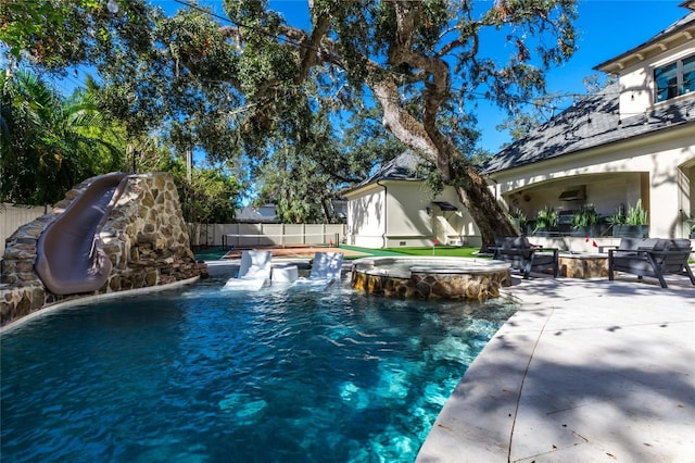 view of swimming pool featuring a patio area and an in ground hot tub