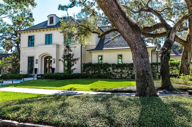 french country inspired facade with a front yard