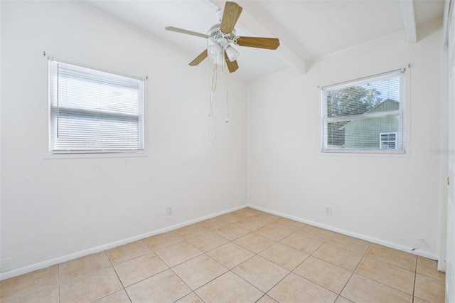 tiled empty room with ceiling fan and beam ceiling