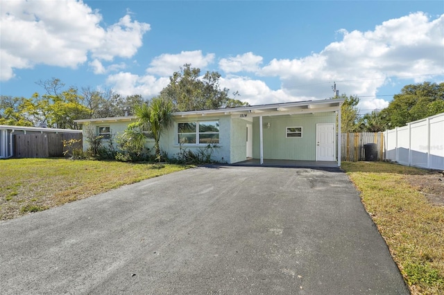 view of front of house featuring a carport and a front lawn