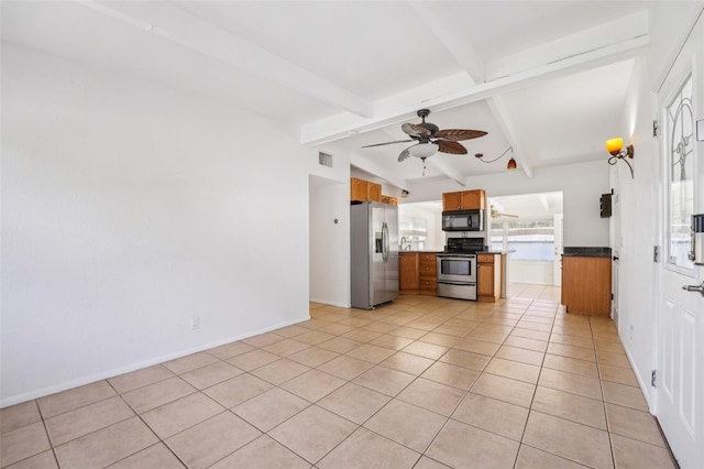 kitchen with lofted ceiling with beams, stainless steel appliances, ceiling fan, and light tile patterned flooring