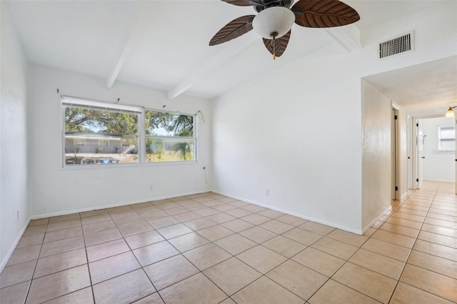 tiled spare room featuring ceiling fan and beam ceiling