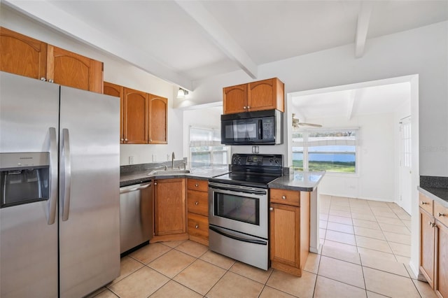 kitchen featuring beamed ceiling, light tile patterned floors, stainless steel appliances, and sink