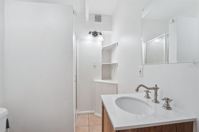 bathroom featuring tile patterned flooring, vanity, toilet, and an enclosed shower