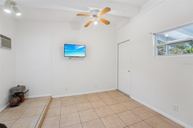 tiled empty room with ceiling fan and beamed ceiling