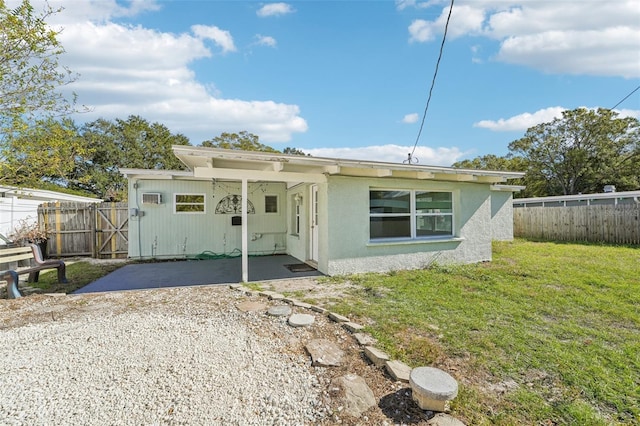 rear view of property with a yard and a patio