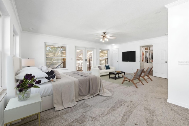 bedroom with light carpet, a walk in closet, ceiling fan, access to exterior, and ornamental molding