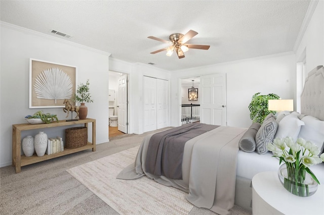 bedroom featuring a textured ceiling, connected bathroom, light colored carpet, and ceiling fan