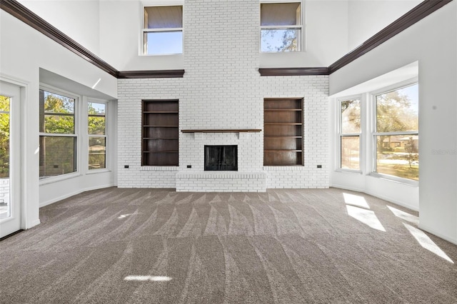 unfurnished living room featuring built in features, plenty of natural light, carpet floors, and a high ceiling