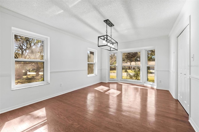 unfurnished dining area featuring plenty of natural light, dark hardwood / wood-style flooring, and a textured ceiling