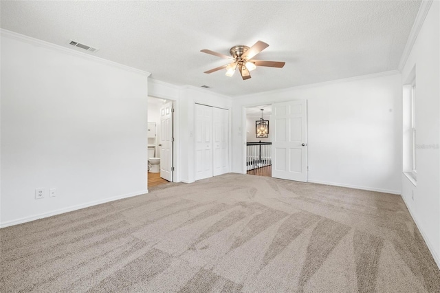 carpeted spare room featuring ceiling fan, a textured ceiling, and ornamental molding