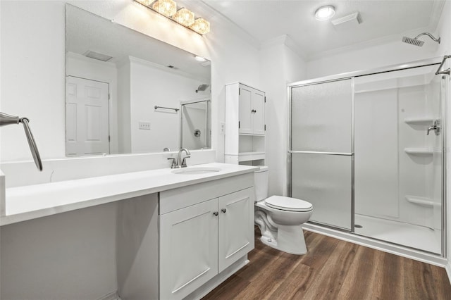 bathroom with vanity, crown molding, hardwood / wood-style floors, toilet, and a shower with shower door