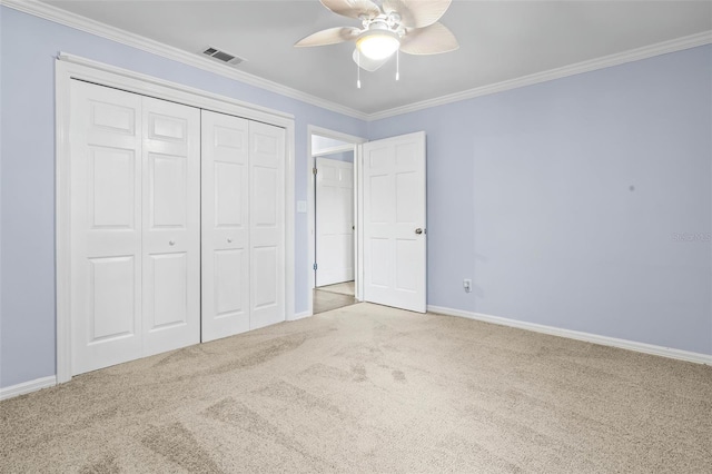 unfurnished bedroom featuring a closet, light carpet, crown molding, and ceiling fan