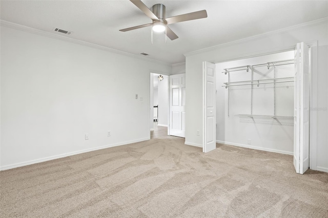 unfurnished bedroom with ceiling fan, a closet, light carpet, and ornamental molding