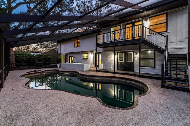 view of swimming pool with glass enclosure and a patio area