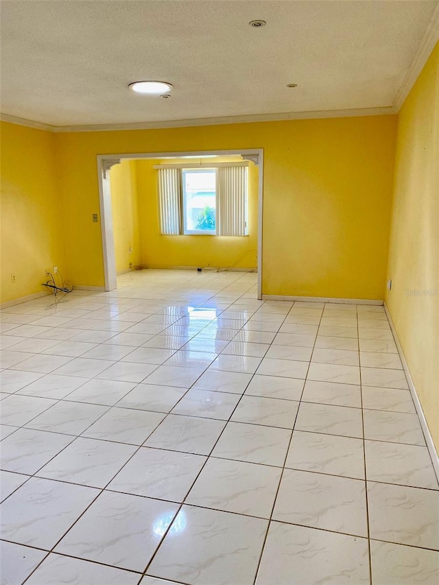 unfurnished room featuring light tile patterned floors, a textured ceiling, and crown molding