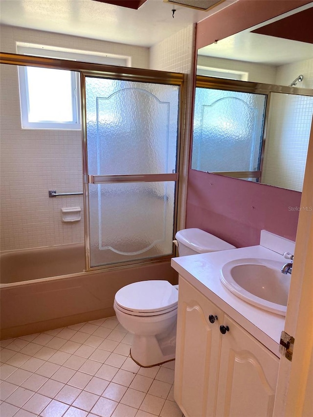 full bathroom featuring tile patterned floors, vanity, toilet, and combined bath / shower with glass door